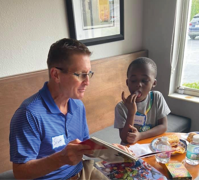 8 Waves volunteer sharing a meal with a student
